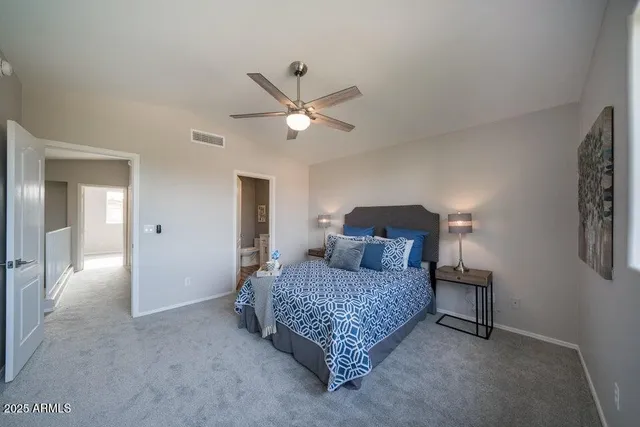 a bedroom with a bed and a lamp with the dresser