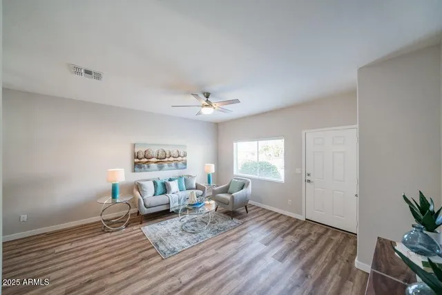 a living room with furniture and a wooden floor