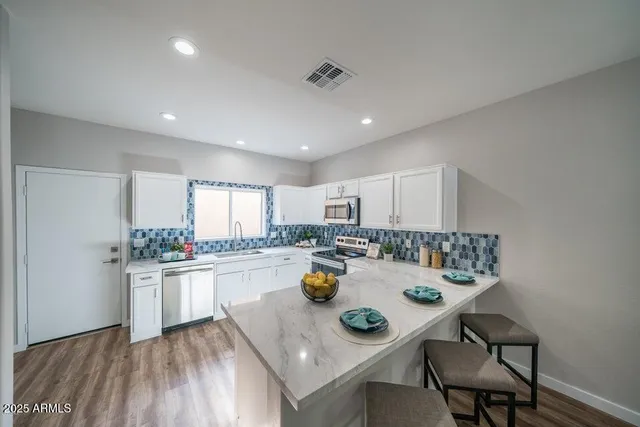 a kitchen with a dining table chairs and stove top oven