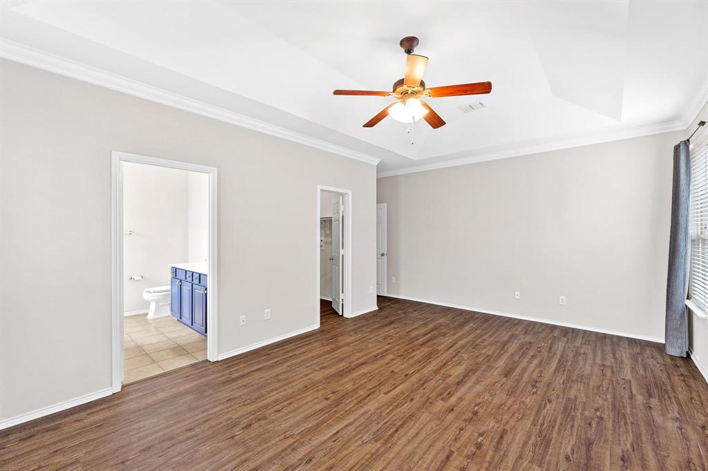 5812 Pebble Ridge Drive McKinney, TX 75070 - Photo 13 of 29 a view of an empty room with wooden floor and a ceiling fan