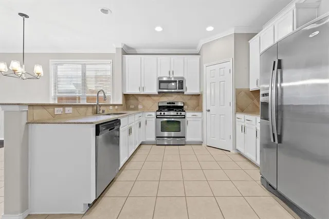 a kitchen with a sink a counter top space stainless steel appliances and cabinets