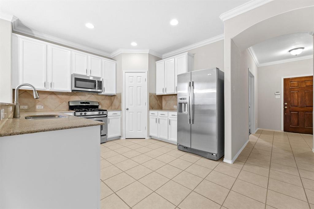 5812 Pebble Ridge Drive McKinney, TX 75070 - Photo 20 of 29 a kitchen with stainless steel appliances granite countertop a refrigerator and a stove top oven