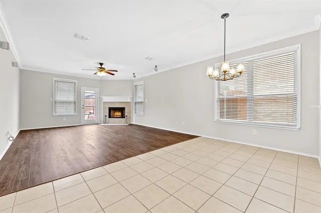 a view of an empty room with a window and kitchen view