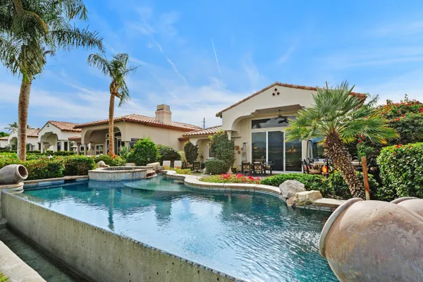 a front view of a house with swimming pool and porch