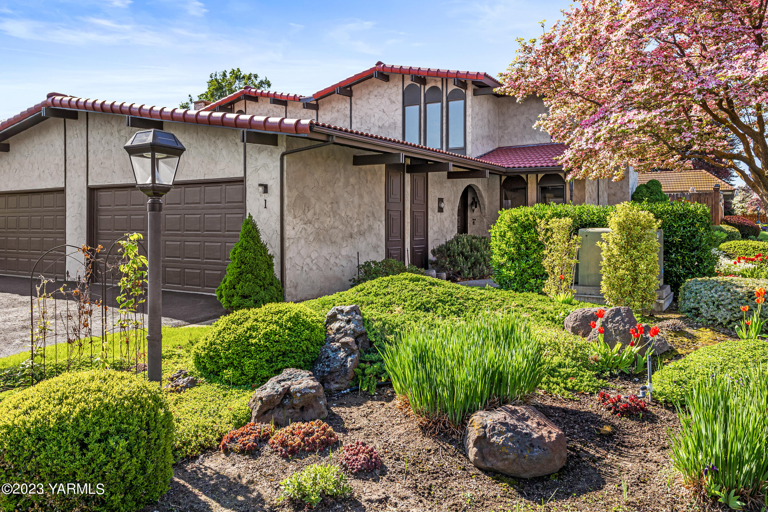 a front view of a house with a yard and plants