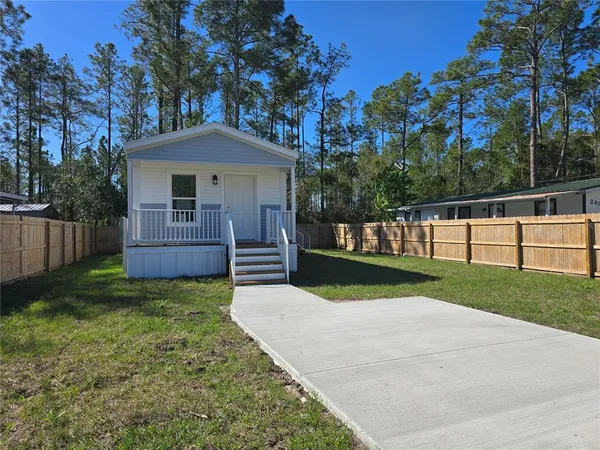 a view of a house with a yard and a garden