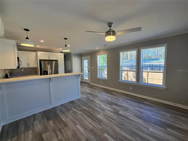 a kitchen with a wooden floor cabinets and stainless steel appliances