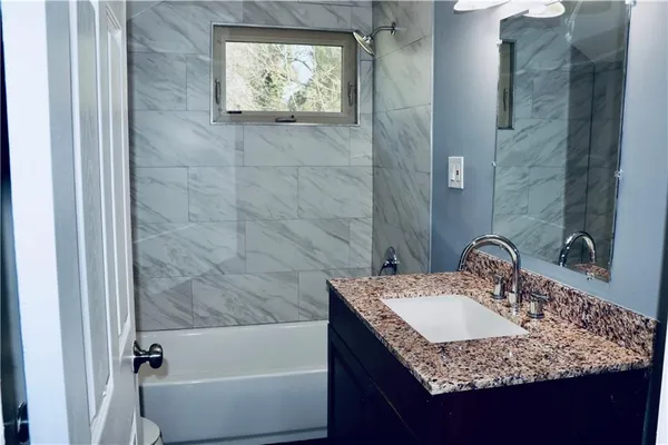 a bathroom with a granite countertop sink and a mirror
