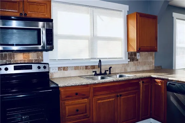 a kitchen with granite countertop a sink and a stove