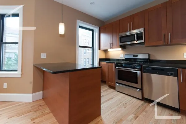 a kitchen with stainless steel appliances granite countertop a stove a microwave and a sink
