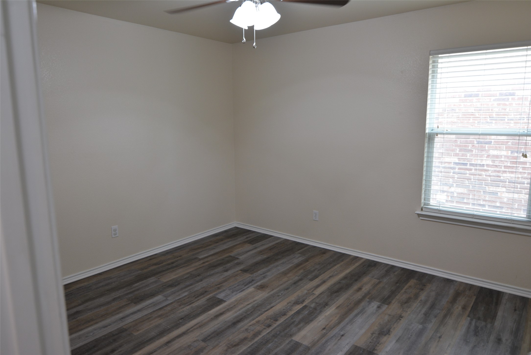 1303 Horseshoe Ranch Drive Leander, TX 78641 - Photo 20 of 26 A well-lit bedroom features durable laminate flooring and a cooling ceiling fan.
