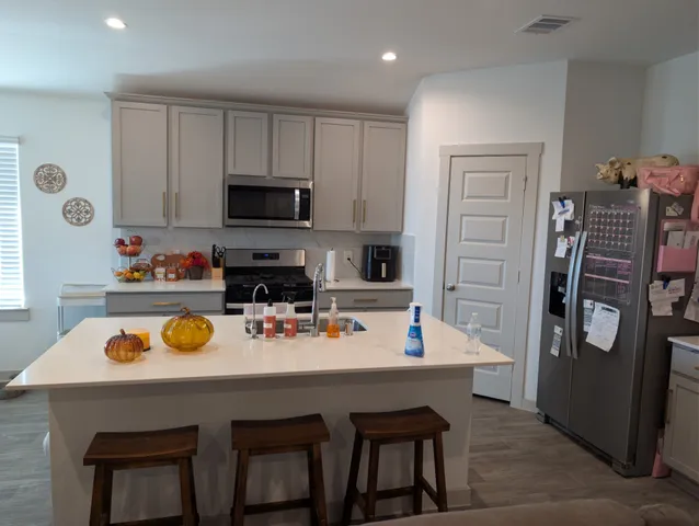 a kitchen with a sink a stove and chairs