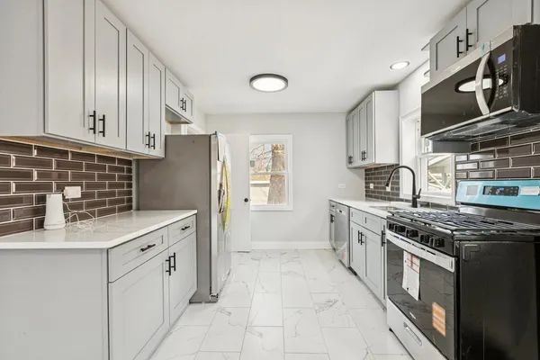 a kitchen with stainless steel appliances granite countertop a stove and a refrigerator