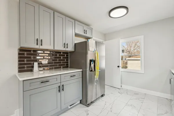 a kitchen with white cabinets and stainless steel appliances