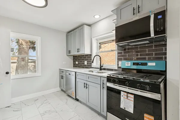 a kitchen with stainless steel appliances a stove and a microwave