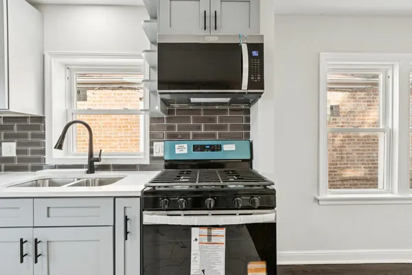 a stove top oven sitting inside of a kitchen