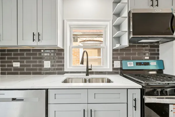 a kitchen with granite countertop a sink and a stove top oven