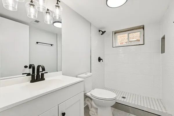 a bathroom with a sink a toilet and shower
