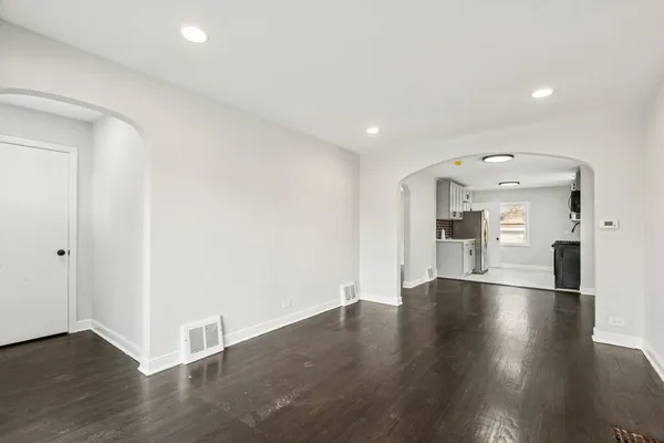 a view of empty room with wooden floor