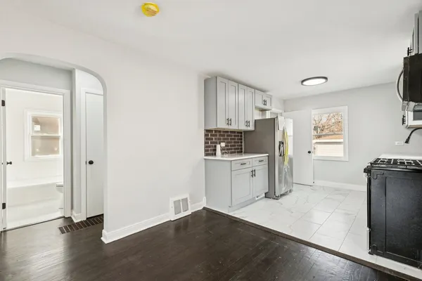 a kitchen with a refrigerator and a stove top oven