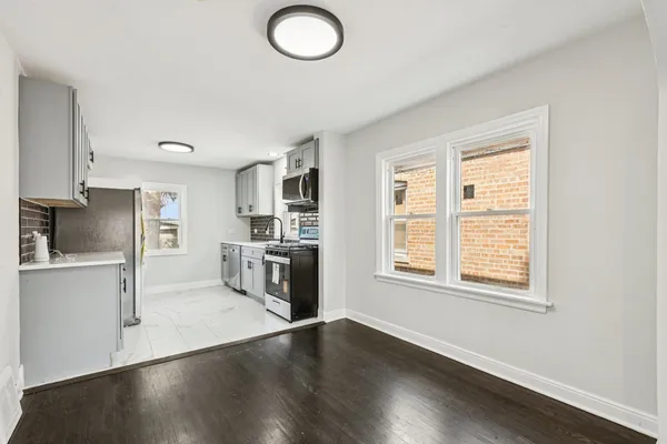 a kitchen with stainless steel appliances granite countertop a sink a stove a refrigerator and a window