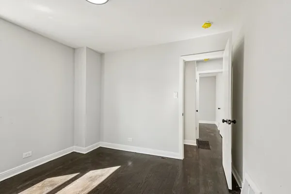a view of an empty room with closet and a window