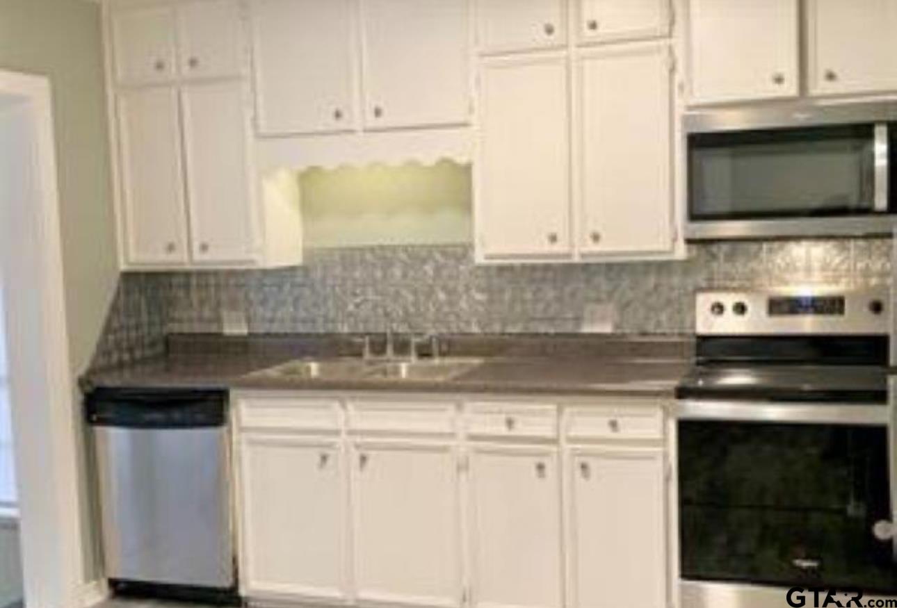 901 Cliff Street Quitman, TX 75783 - Photo 3 of 15 a kitchen with stainless steel appliances granite countertop a sink and a microwave