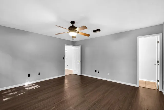 a view of wooden floor and a chandelier fan in living room