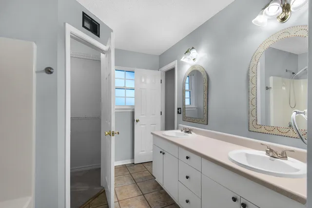 a bathroom with a double vanity sink and a mirror