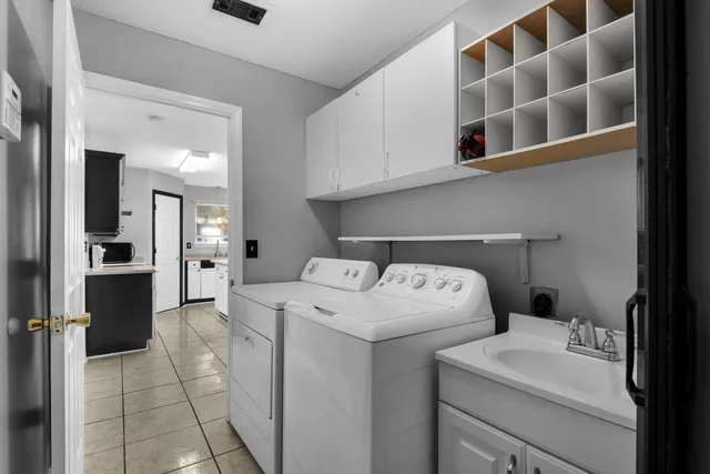 a view of washer and dryer with kitchen in the background