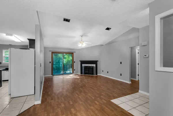 a view of a livingroom with wooden floor a ceiling fan and window