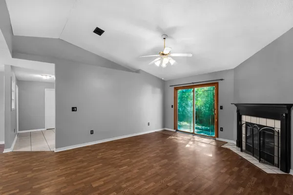 a view of an empty room with a fireplace and a window