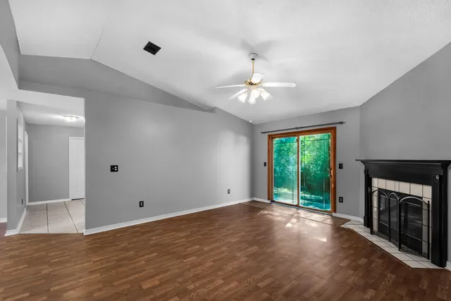 a view of an empty room with a fireplace and a window