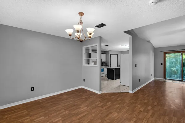 a view of a big room with wooden floor and chandelier
