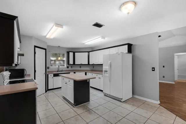 a kitchen with a sink a refrigerator and cabinets