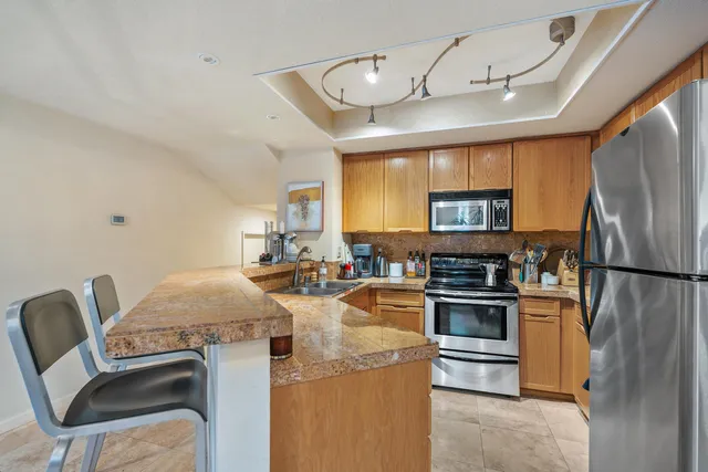 a kitchen with stainless steel appliances granite countertop a sink stove and refrigerator