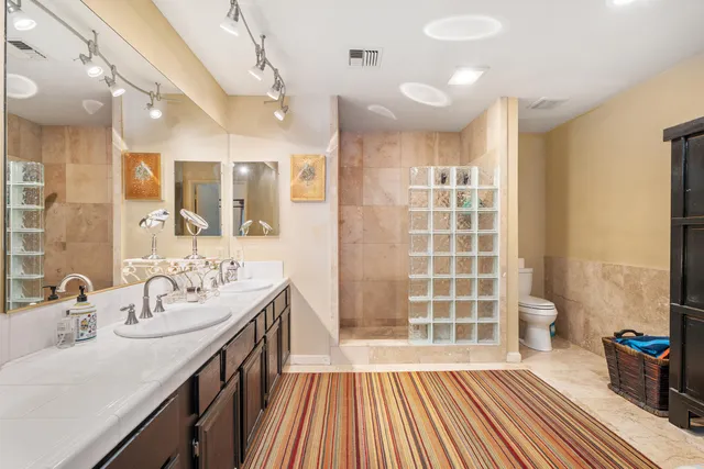 a spacious bathroom with a double vanity sink a mirror and a shower