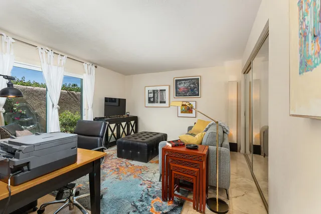 a living room with furniture a large window and a flat screen tv