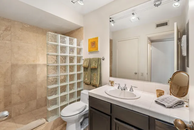 a bathroom with a sink a toilet and shower