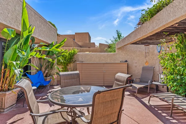 a backyard with table and chairs with potted plants