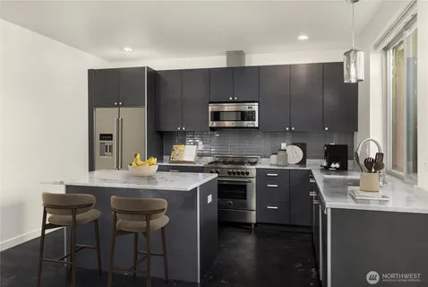 a kitchen with kitchen island a sink stove and microwave