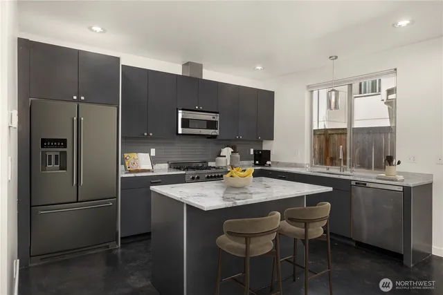 a kitchen with stainless steel appliances granite countertop a sink stove and refrigerator