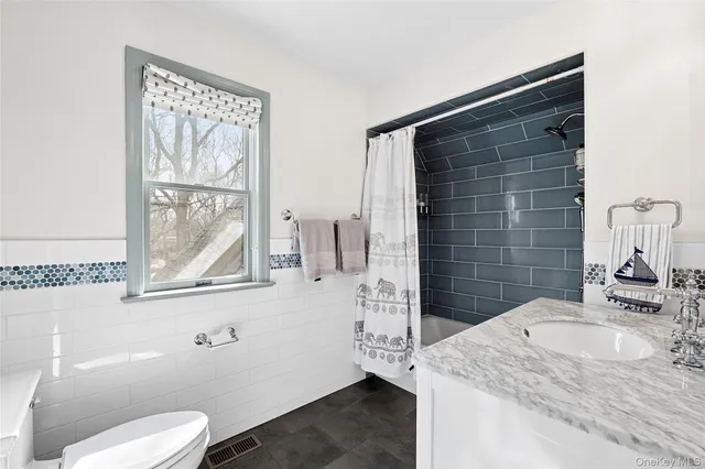 a bathroom with a granite countertop sink toilet and shower