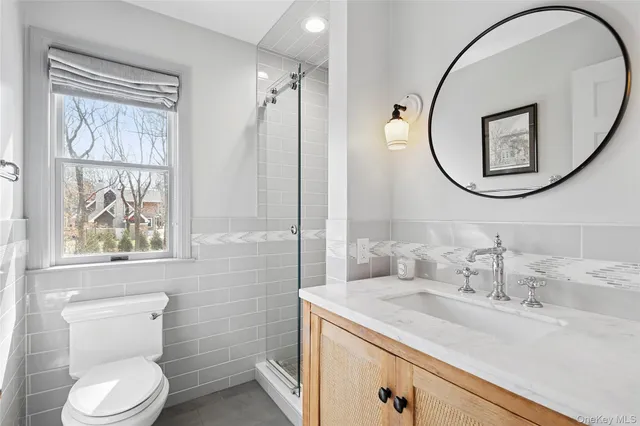 a bathroom with a granite countertop sink a toilet and a mirror