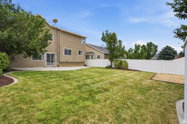 2223 North Pointe Meadow Loop Lehi, UT 84048 - Photo 39 of 56 Expansive backyard featuring a manicured lawn, a large concrete patio, and a white privacy fence