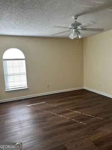 a view of a room with wooden floor and fan