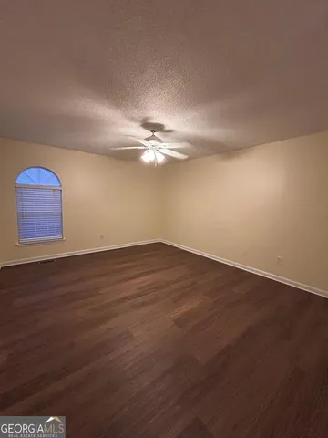 a view of a room with wooden floor and fan