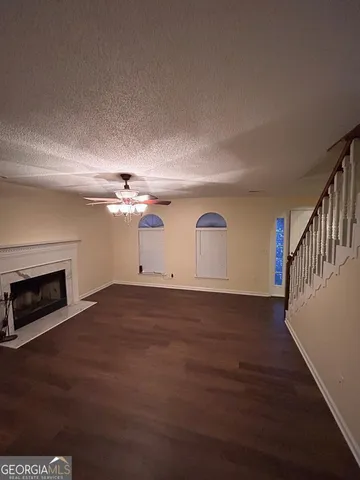 a view of empty room with wooden floor and fireplace