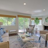 a living room with fireplace furniture and a large window