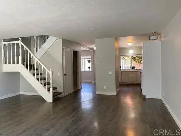 a view of a hallway with wooden floor and windows